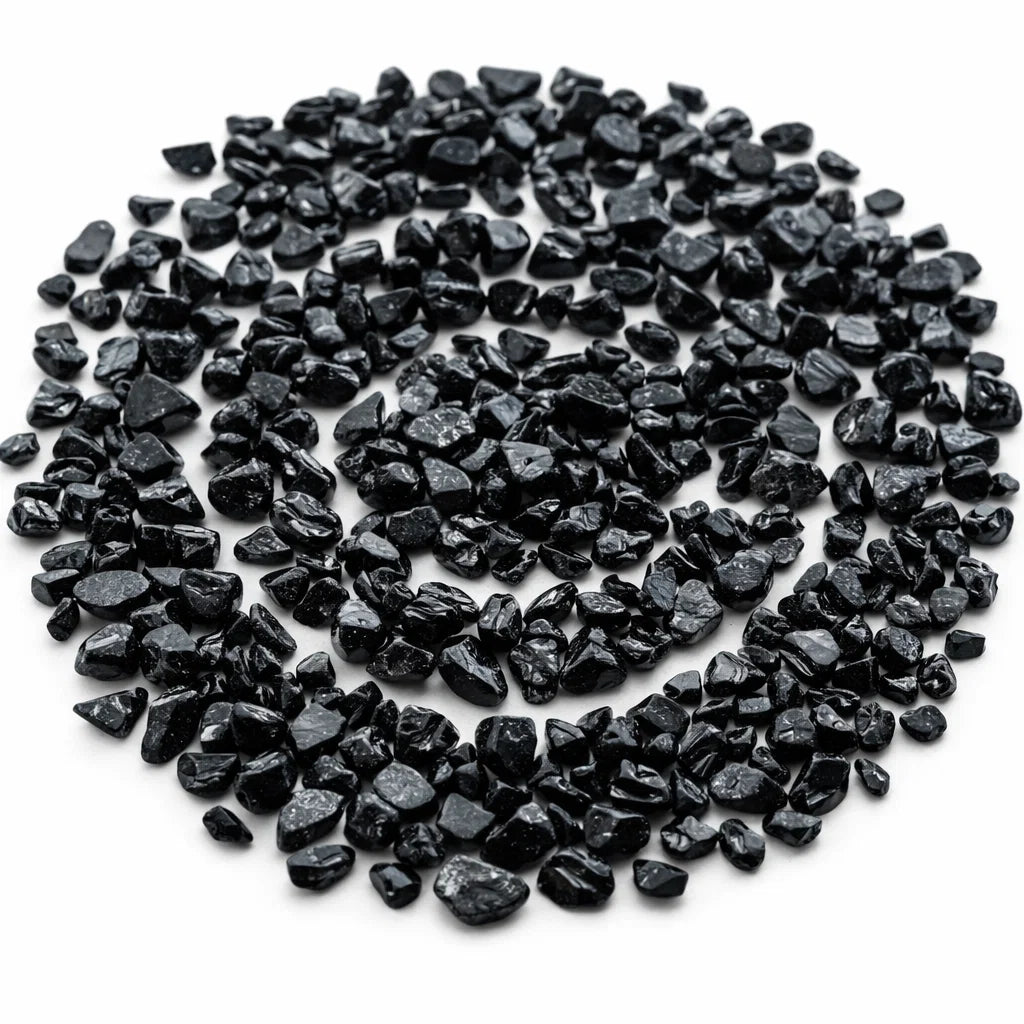 Pile of black tourmaline crystal chips on a clean white background