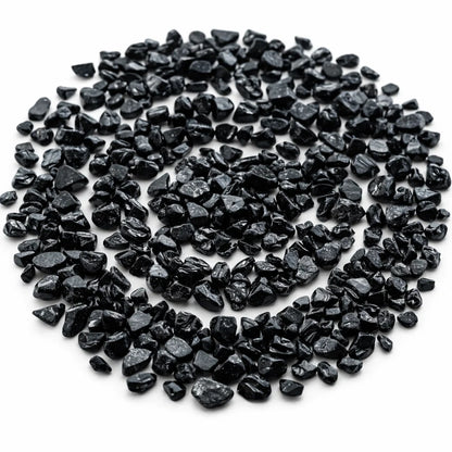 Pile of black tourmaline crystal chips on a clean white background