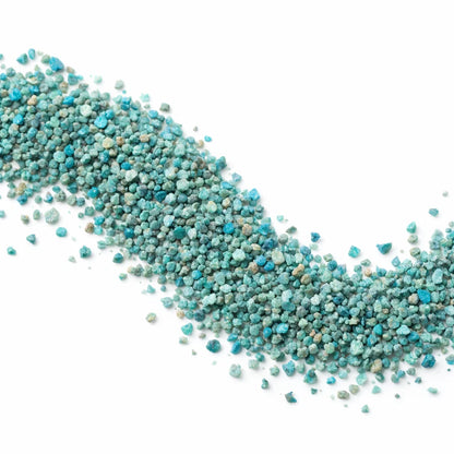 Pile of blue apatite crystal chips on a clean white background