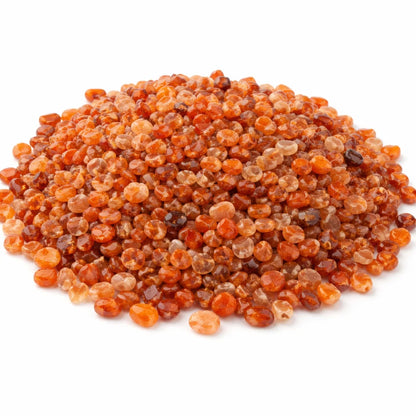 Pile of carnelian crystal chips on a clean white background