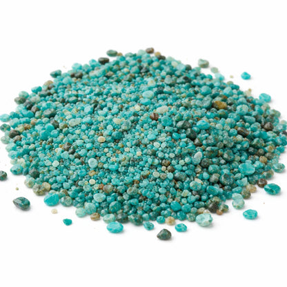 Close-up of chrysocolla crystal chips on a clean white background showing natural colour and texture