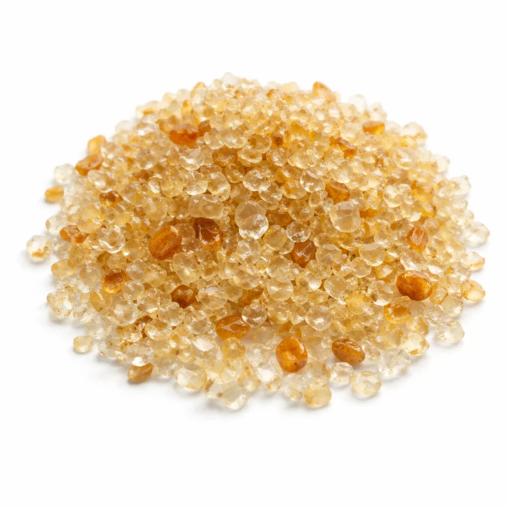Pile of citrine crystal chips on a clean white background