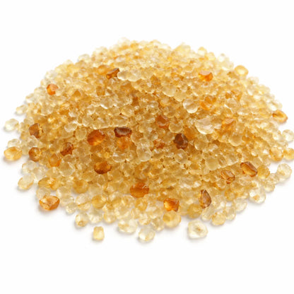 Close-up of citrine crystal chips on a clean white background showing natural colour and texture