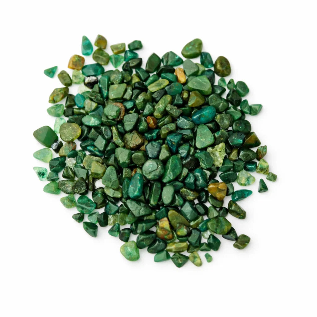 Pile of emerald crystal chips on a clean white background
