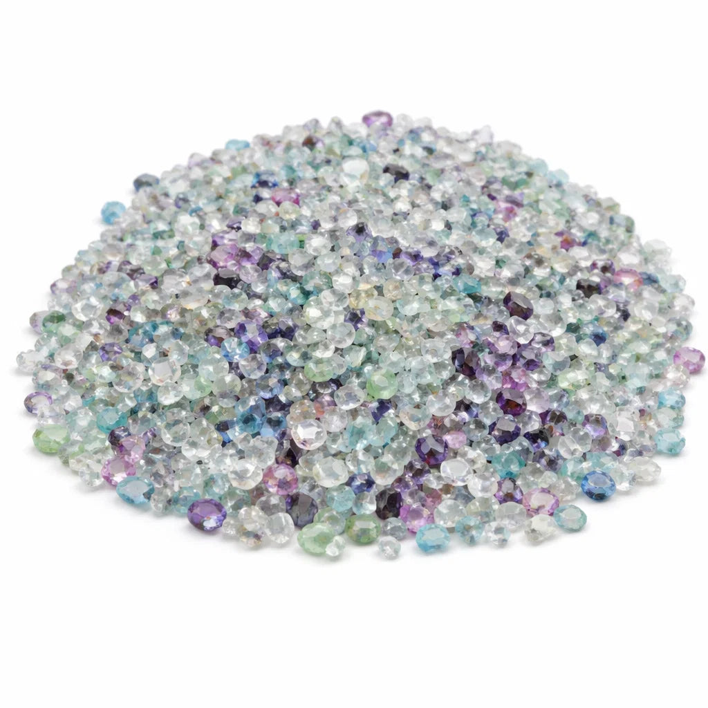 Close-up of fluorite crystal chips on a clean white background showing natural colour and texture