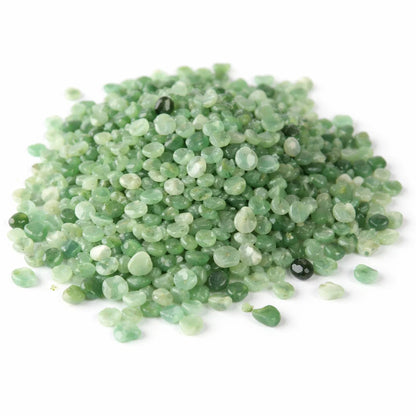 Pile of green aventurine crystal chips on a clean white background