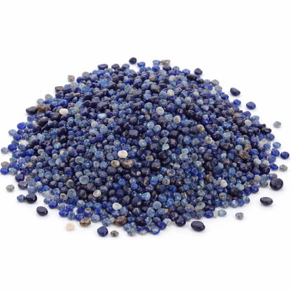 Pile of lapis lazuli crystal chips on a clean white background
