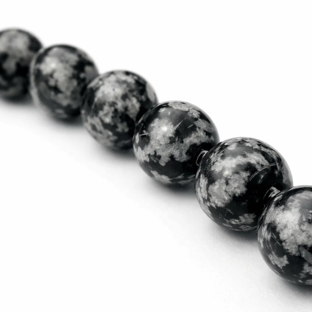 Natural snowflake obsidian crystal bracelet displayed in a softly lit product setting