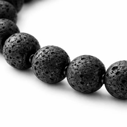 Natural volcanic lava bracelet displayed in a dark, softly lit spiritual setting