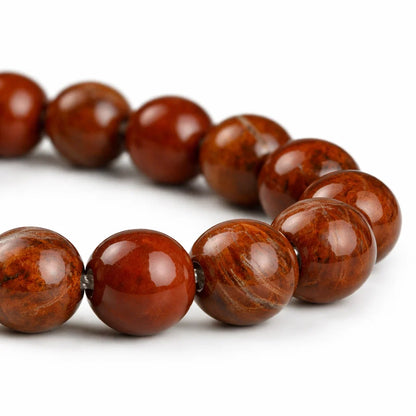 Natural red jasper crystal bracelet presented with a hand for visual scale