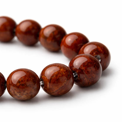 Natural red jasper crystal bracelet shown in a separate hand-held product photograph