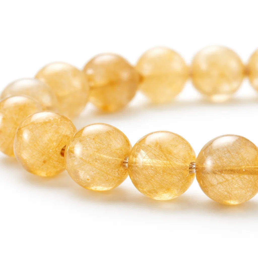 Natural rutile quartz crystal bracelet presented with a hand for visual scale
