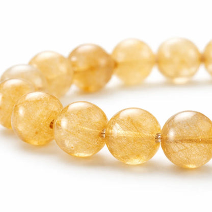 Natural rutile quartz crystal bracelet presented with a hand for visual scale