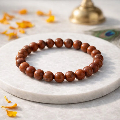 Natural red jasper crystal bracelet shown in a second hand-held product view