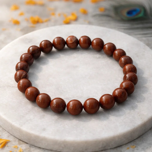 Natural red jasper crystal bracelet shown with a hand in a lifestyle photograph