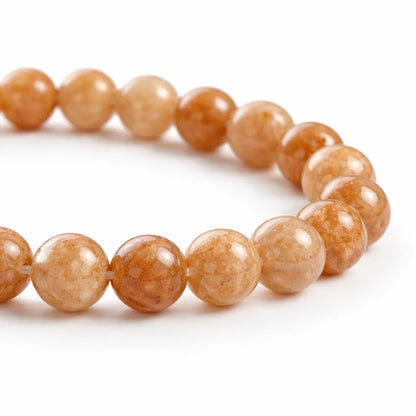 Natural sunstone crystal bracelet presented with a hand for visual scale