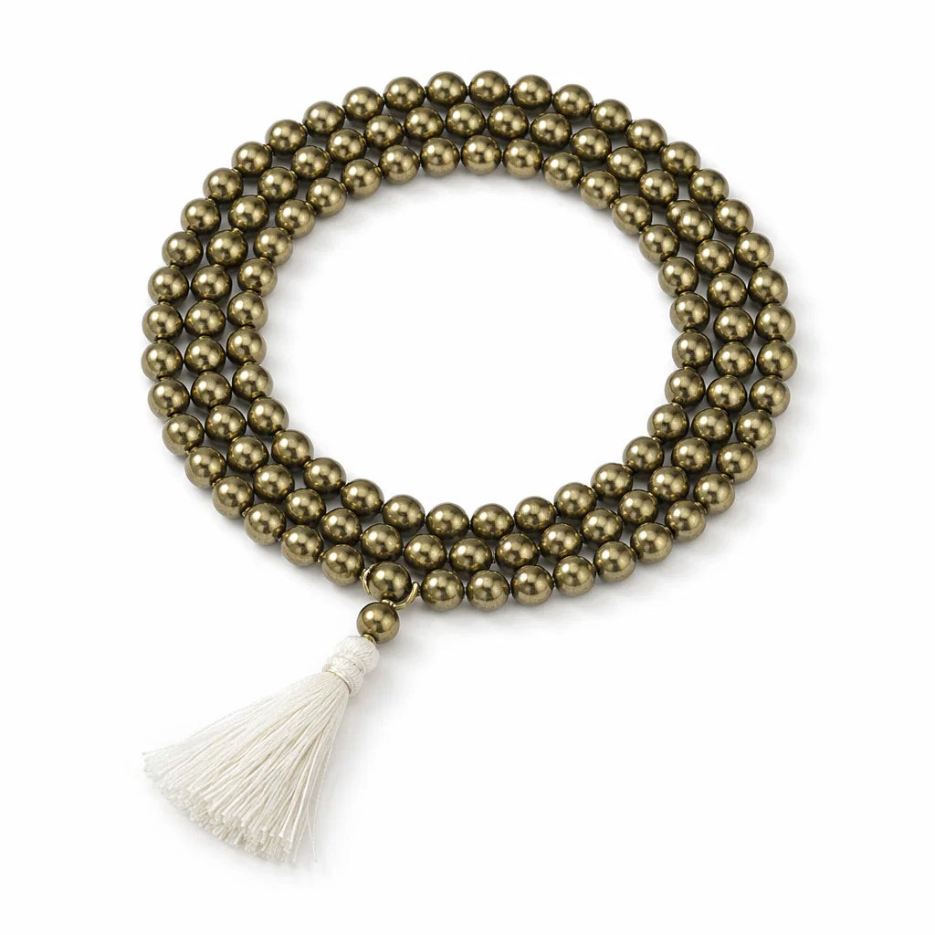 Coiled pyrite crystal mala with a cream tassel isolated on a clean white background