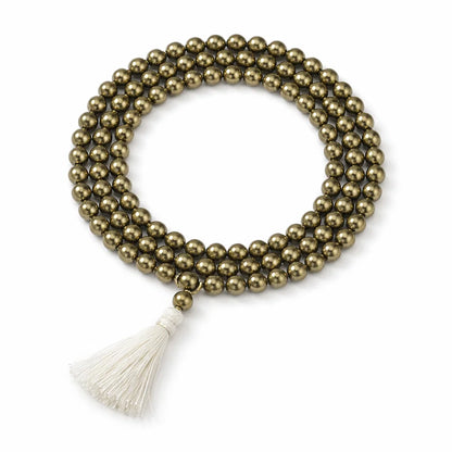 Coiled pyrite crystal mala with a cream tassel isolated on a clean white background
