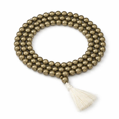Full pyrite crystal mala arranged in a circle with its cream tassel on white