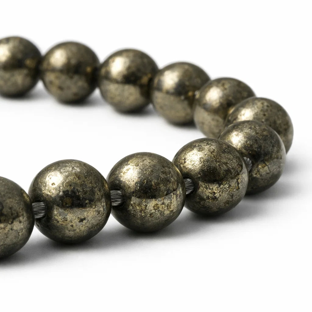 Close-up of pyrite mala beads and string knots on a white background