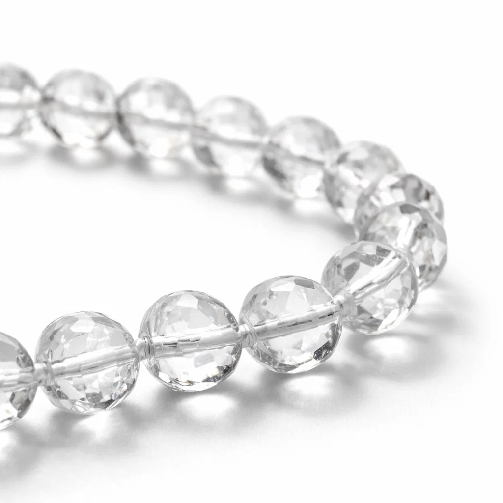 Close-up of clear sphatik mala beads showing faceted surfaces and string knots