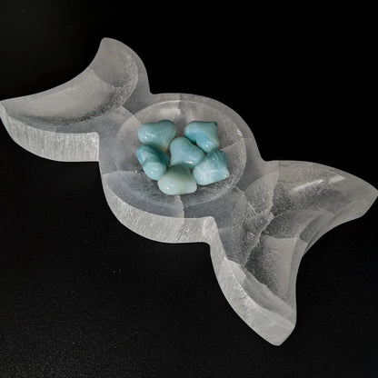 Triple moon selenite charging bowl shown in a close atmospheric product view